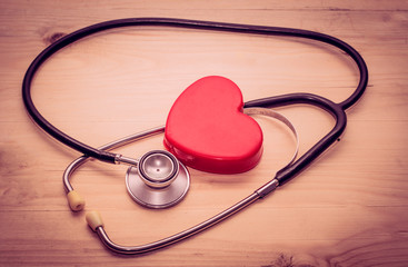 Medical stethoscope and heart  on Old wooden tables