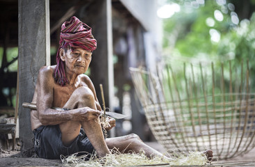 Fototapeta na wymiar The old man sharpening bamboo make everything for sale.