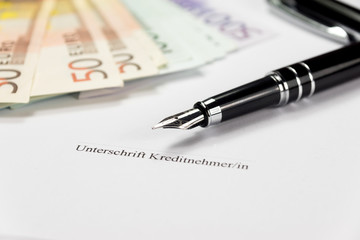 Unterschrift auf einem Kreditvertrag und Bargeld