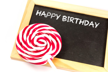 Ein Lutscher und eine Tafel mit dem Text Happy Birthday