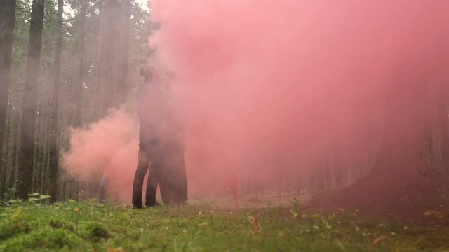 man and a woman in black robes standing in the woods