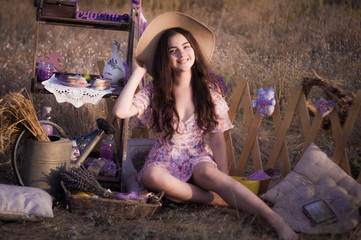 Happy girl in a hat in a field with decor