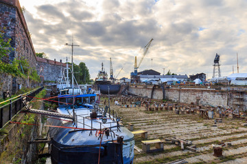 Ship and boats in old dockyard on Suomenlinna in Finland.