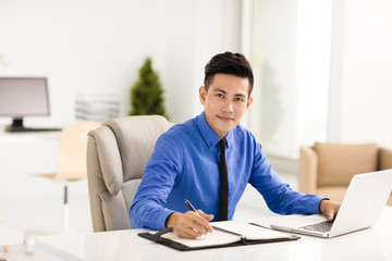 young smiling business man working in office