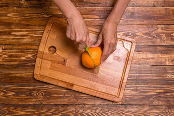 Girl cuts an orange for fresh juice