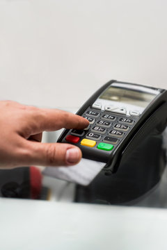 Credit or debit card password payment. Customer hand is entering pin