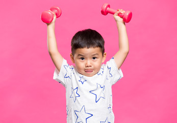 Little boy raising up dumbbells