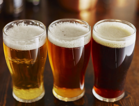 three different types of beer in glass mugs