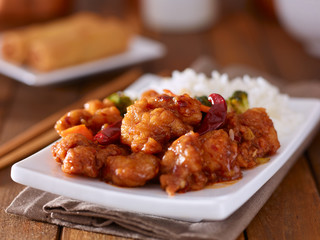 plate of chinese general tsos chicken with rice and broccoli