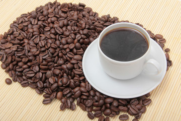 Coffee beans and a white cup on table