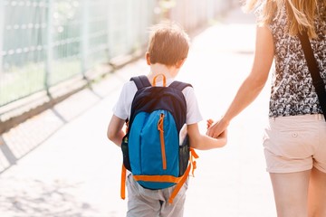 7 years old boy going to school with his mother