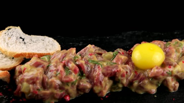 Beef tartare with egg yolk on the black stone board