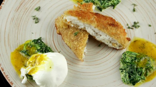 Fried fish fillet with soft poached egg and spinach, loop