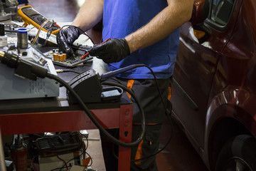 Mechanic fixing an electronic car parts in his workshop
