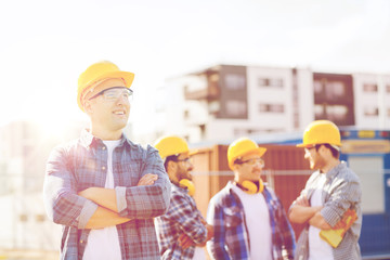 group of smiling builders in hardhats outdoors