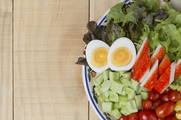 Closeup fresh vegetables salad with boil egg and crab stick