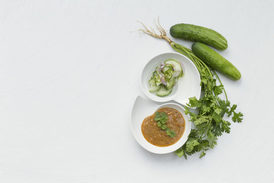 Cucumber with red onion salad and peanut sauce with space on white background