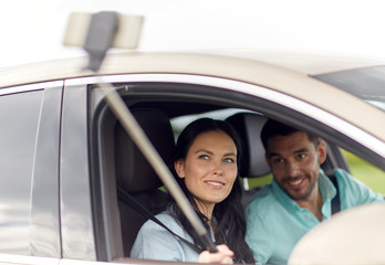 Fototapeta premium happy couple in car taking selfie with smartphone