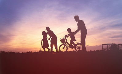 Fototapeta na wymiar Happy asian family playing at grass on sunset