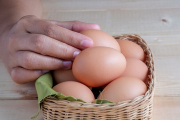 hand holding egg on wooden background