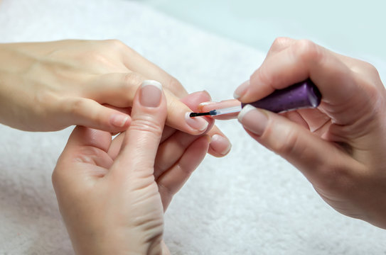 Woman hands in a nail salon receiving a manicure by a beautician