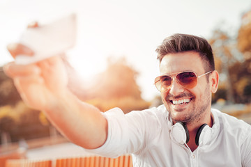 Portrait of a happy man with beard taking selfie