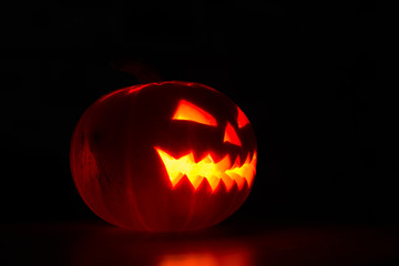 Illuminated halloween pumpkin on black background
