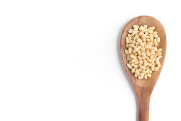 Pine nuts into a spoon in white background