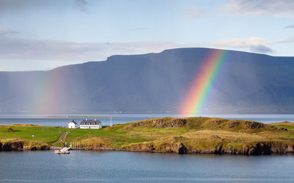 Reykjavik Landscape.  The view from Reykjavik harbour in Iceland as rain falls and a rainbow forms.  In the background is the Esja volcanic mountain range.