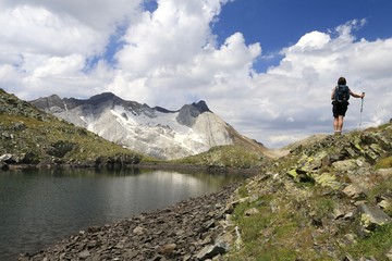 Fototapeta na wymiar Femme pratiquant la randonnée en montagne au lac des Gentianes et Pic du Vignemale Pyrénées