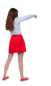 skinny woman funny fights waving his arms and legs. Isolated over white background. Long-haired brunette in red skirt boxing.