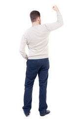 Fototapeta premium Back view of man. Raised his fist up in victory sign. Rear view people collection. backside view of person. Isolated over white background. The bearded man in a white warm sweater triumphantly