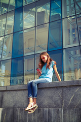 Outdoor shot of stylish girl holding a smartphone,wearing sungla