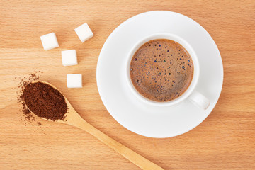 ground coffee in a wooden spoon on the table