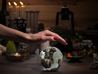 Hands witch. Transparent sphere. Magical objects and utensils of the alchemist. Candles, herbs. Concept - alternative medicine, witchcraft and the occult. Halloween. Divination, sorcery. Work Healer