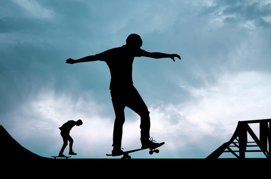 boys with skateboard at sunset