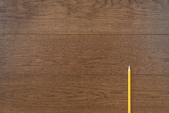 yellow pencil on wooden background