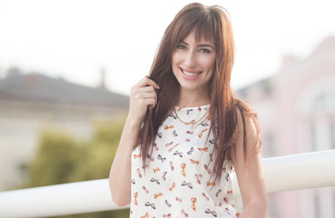 Fototapeta premium Young smiling woman outdoors portrait. Soft sunny colors. Outdoor closeup fashion portrait of young pretty woman in summer meadow.
