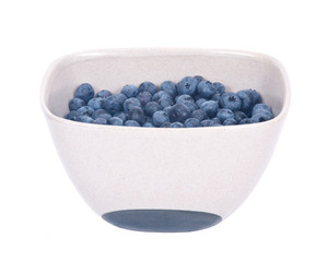 Organic blueberry in ceramic bowl separated on white background