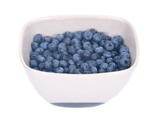 Organic blueberry in ceramic bowl separated on white background