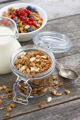 jar with homemade granola, milk and fresh berries 