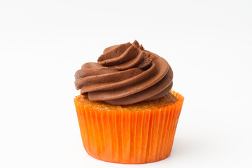 A chocolate orange cupcake with swirled frosting on an isolated white background.