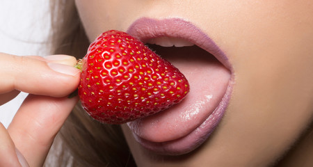 female lips eating red strawberry
