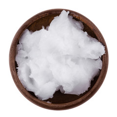 Coconut oil in a bowl on white background. Also copra oil, an edible oil, extracted from the kernel...