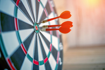 Red dart arrow hitting in the target center of dartboard business success ideas concept - Powered by Adobe