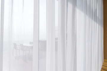 view seascape looking pass Translucent white fabric curtains and