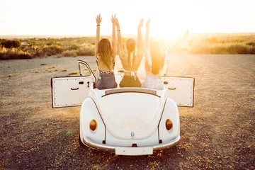 Foto op Canvas Three pretty young women driving on road trip on beautiful summe © nenetus