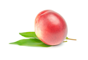 single nectarine with green leaves over white background