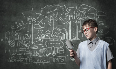 Curious school boy with magnifier