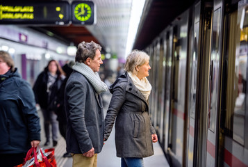 Senior couple standing at the underground platform, waiting